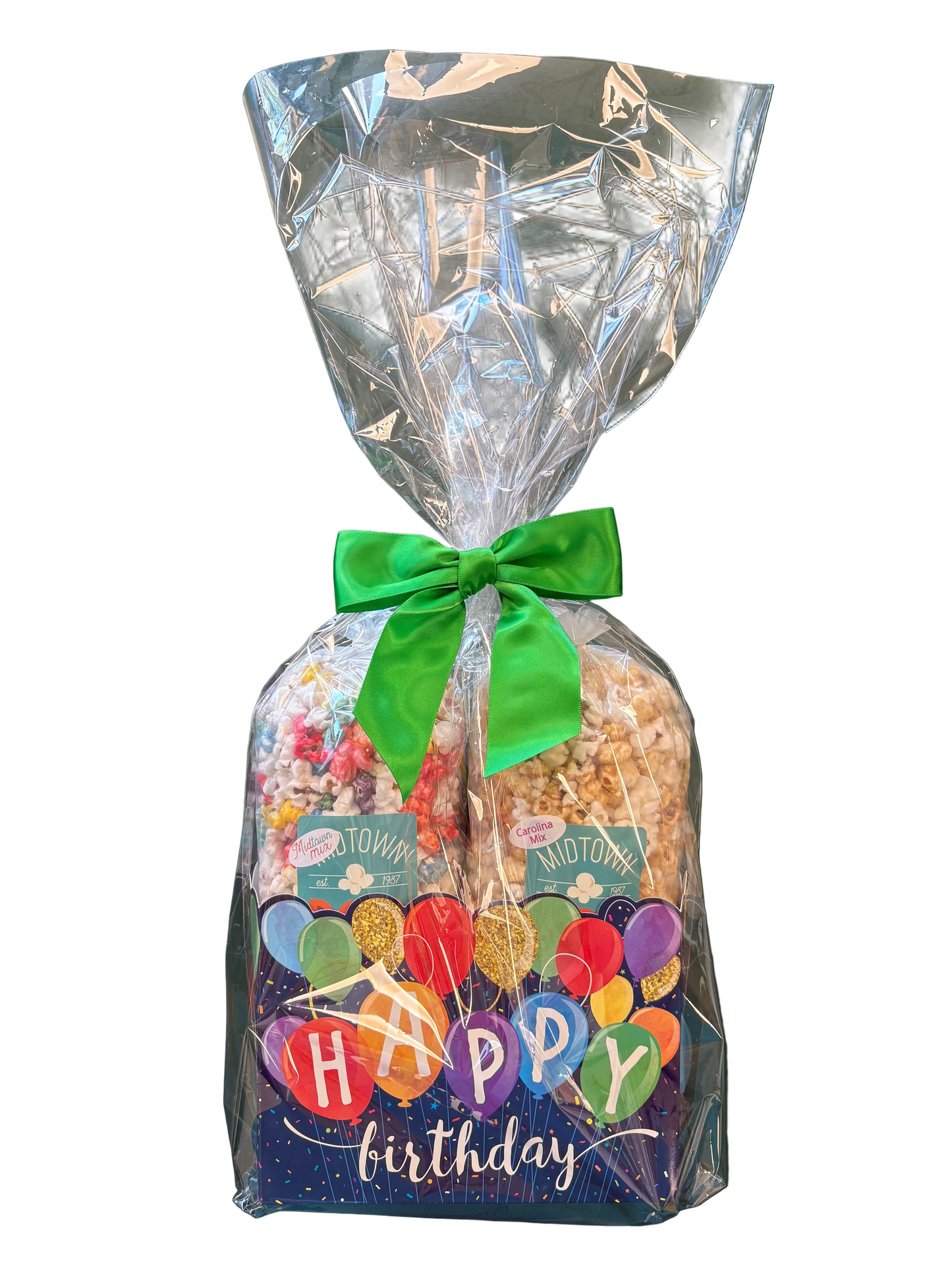 Gift bag with a green ribbon, colorful 'Happy Birthday' text, and a clear plastic cover