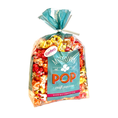 A bag of fall colored popcorn filled with candy coated popcorn treats, Thanksgiving table